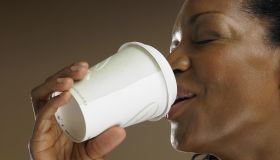 Mature woman drinking from disposable cup, close-up