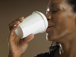 Mature woman drinking from disposable cup, close-up