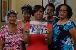 Five members of the Sistahs on the Reading Edge book club, all of Antioch, Calif., from left, Katherine Neal, Georgia Lewis, Lisa Renee Johnson, Allisa Carr and Sandra Jamerson, stand together at  Johnson's home in Antioch on August 24, 2015. The five were among 11 women, 10 of whom are black, booted off the Napa Valley Wine Train. Johnson holds a photograph of the group that was taken before boarding the train. (Jose Carlos Fajardo/Bay Area News Group/TNS via Getty Images)