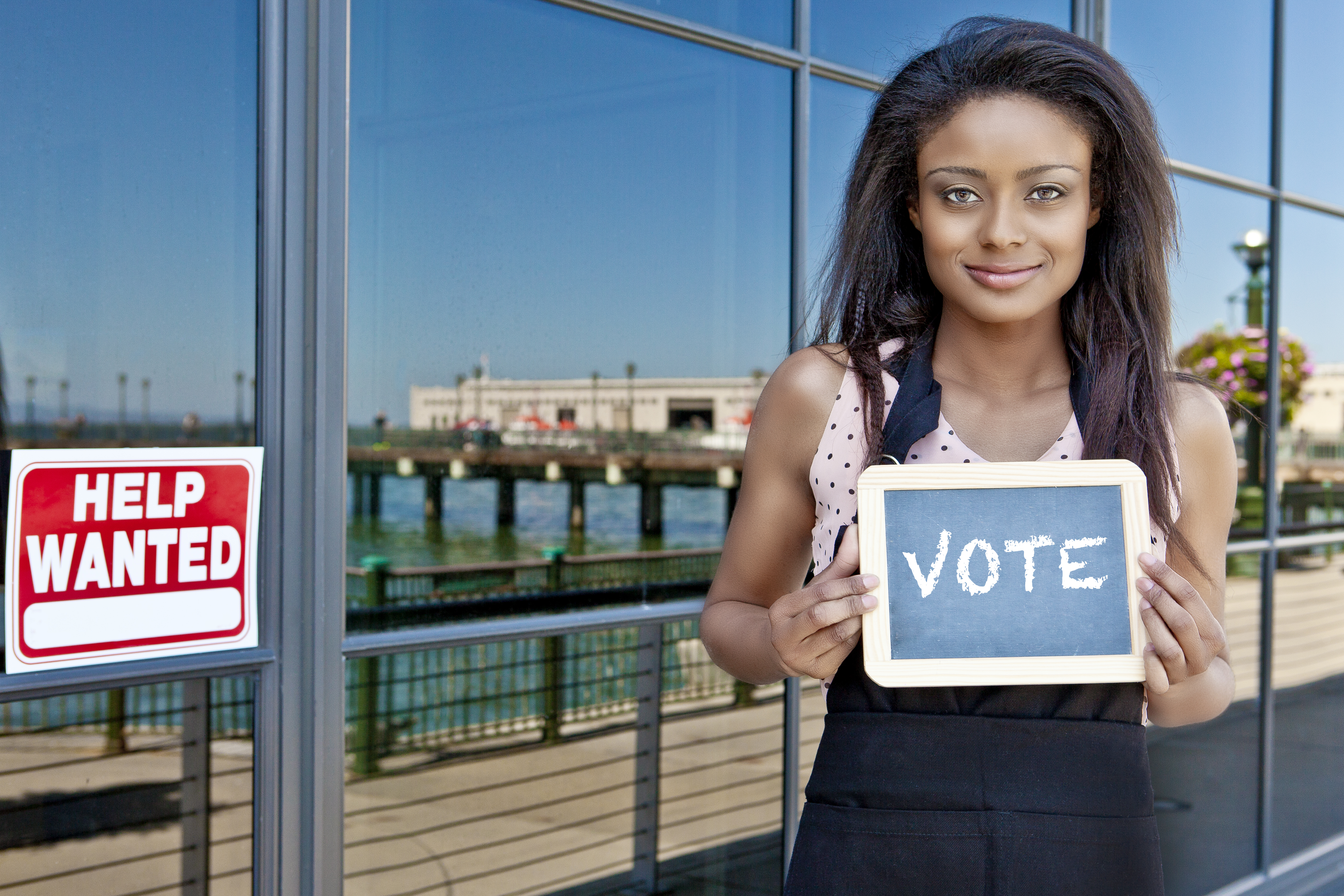 Young woman holding a sign that says 'VOTE'