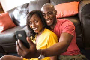 afro couple take a selfie on the couch
