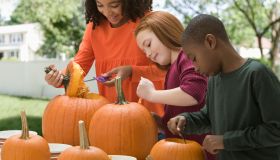 Children carving Halloween pumpkins together