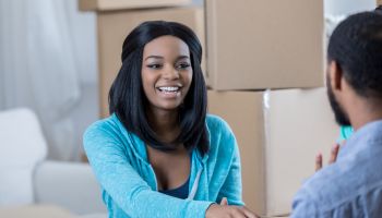 Young African American couple unpack in their new home