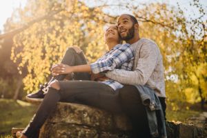 Happy embraced black couple enjoying in autumn day together.