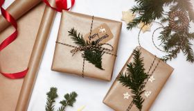 Christmas gifts wrapped in brown paper, decorated with fern and string, overhead view