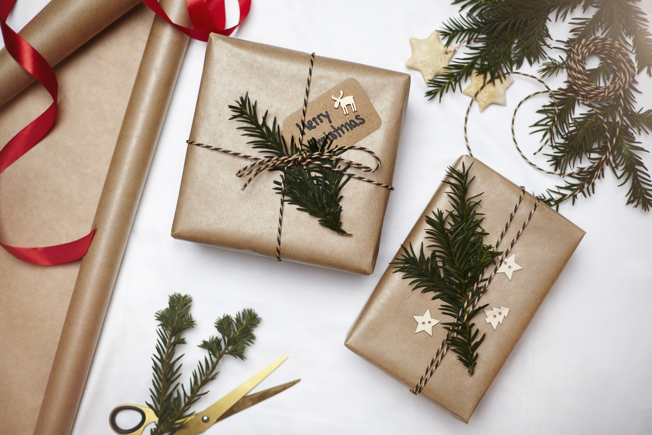 Christmas gifts wrapped in brown paper, decorated with fern and string, overhead view