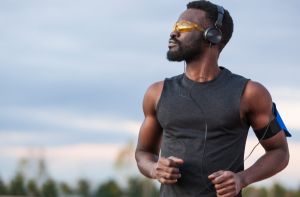 Active african american man training outdoors and listening to music