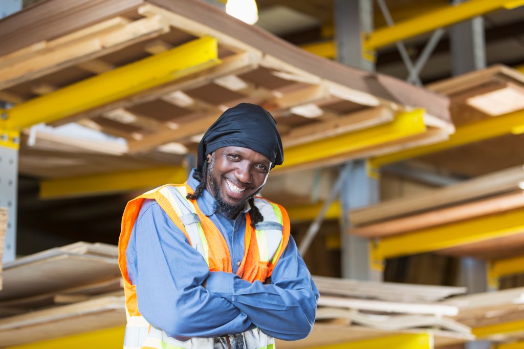 Black man working in warehouse wearing safety vest