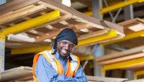 Black man working in warehouse wearing safety vest