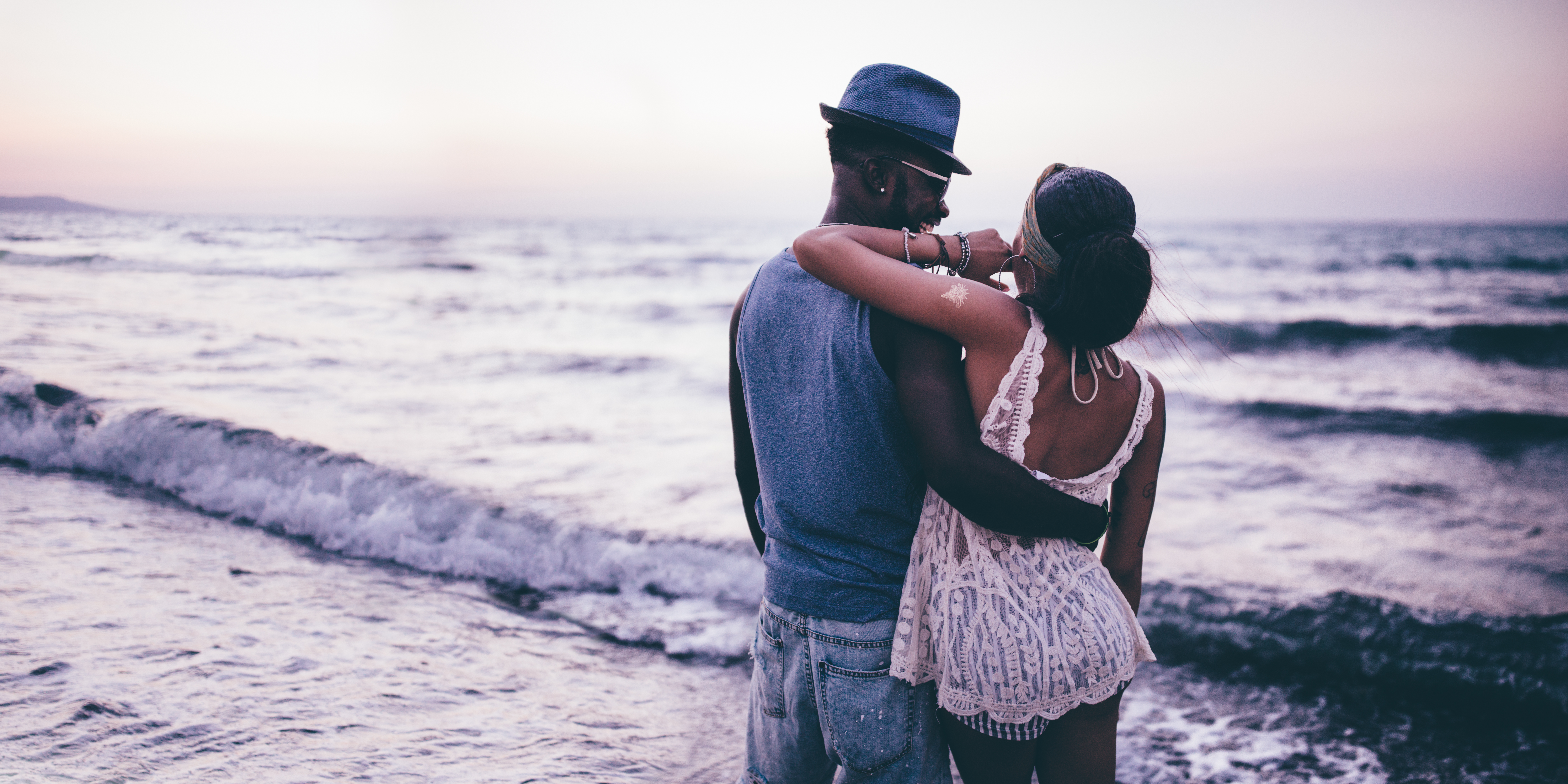 Young hipster couple in love relaxing and embracing at beach