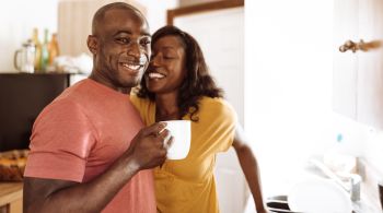 couple embracing in the kitchen and take a coffee