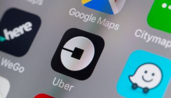 The buttons of the App 'Uber' and other travel Apps on a cellphone screen