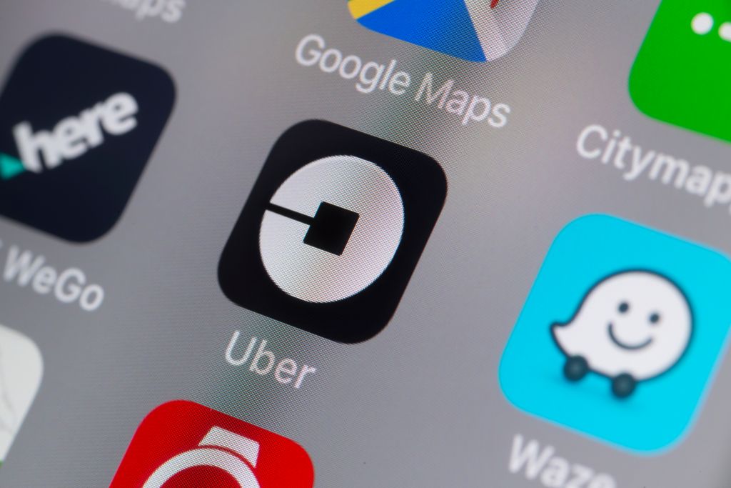 The buttons of the App 'Uber' and other travel Apps on a cellphone screen