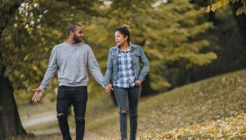 Young African American couple taking an autumn walk and communicating.