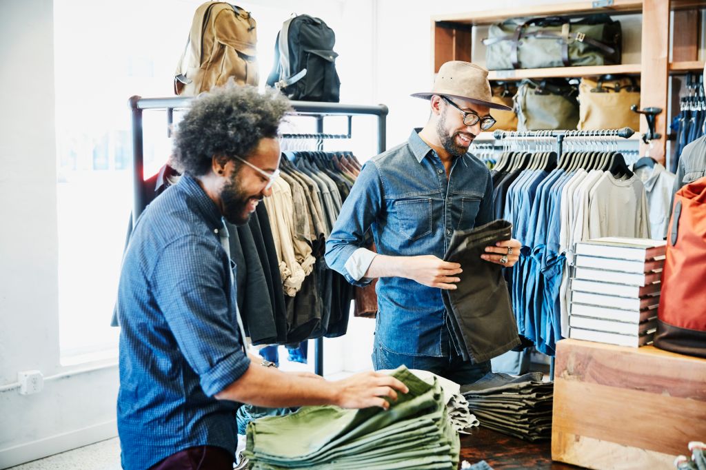 Smiling friends shopping in mens clothing boutique