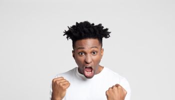 Excited afro american man shouting with clenched fists