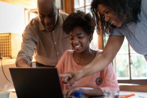 Parents helping daughter while using computer