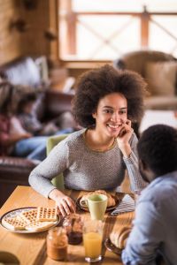 Happy African American couple talking during breakfast time at home.