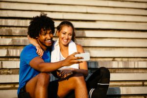 Young fit couple relaxing after workout and taking Selfie