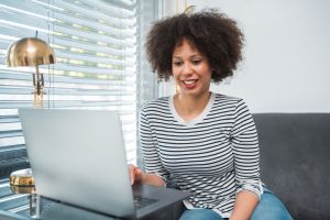 African American young woman using laptop in the living room