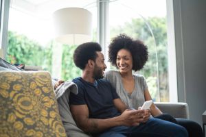 Afro couple using cellphone at home