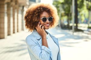 Woman talking on smart phone at sidewalk in city