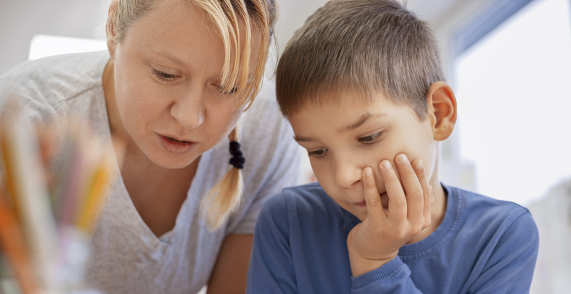 Teacher helping his student in school