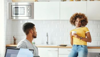 Young couple talking in kitchen at home