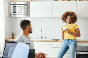 Young couple talking in kitchen at home
