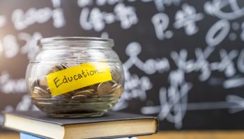 Many money coin in the glass jar with 'Education" wording