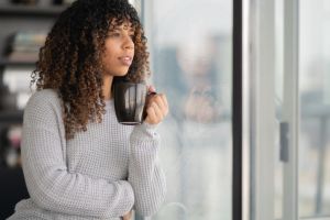 Portrait of a beautiful black woman drinking tea by window
