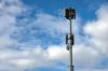 Mobile phone repeater tower against a cloudy blue sky