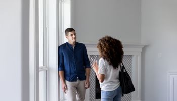Attentive young man talks with wife in new home