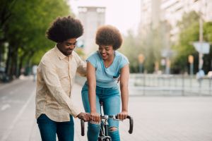 Boyfriend teaching his girlfriend how to ride a bicycle