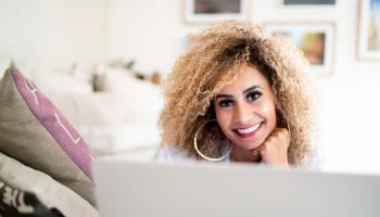 Portrait of mid adult woman using laptop at home