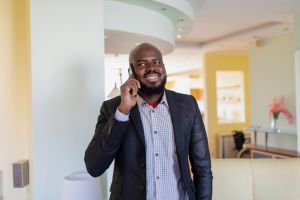 Self-Confident African Businessman at Home Using a Mobile Phone