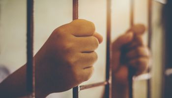 Cropped Hands Of Prisoner In Jail