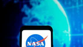 In this photo illustration a NASA logo seen displayed on a...