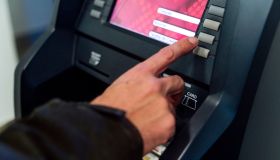 Man typing secret number from a bank ATM to withdraw money
