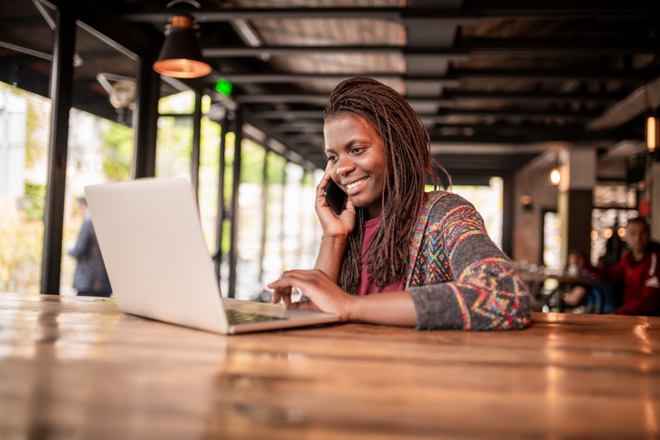 Smiling African woman using laptop.
