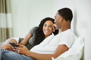 Happy couple talking while using digital tablet