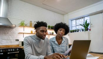 Black couple at home paying the bills online