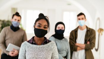 Employees posing in office with face masks