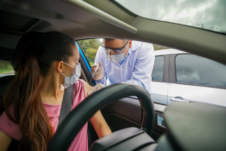 Woman getting the COVID-19 vaccine at a drive through center