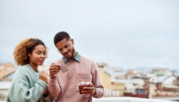 Couple Looking At Instant Print Selfie On Rooftop