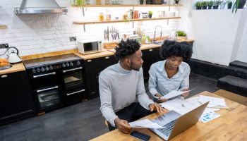 Black couple at home paying the bills online