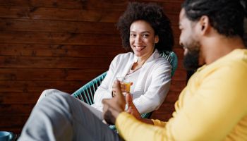 Happy black couple talking while relaxing at home.
