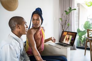 African American Non-binary person and transgender woman in video call of couple online psychotherapy. Telemedicine and mental healthcare concept.