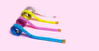 Set of Colored Tapes Measure on Pastel Pink Background.