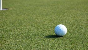 Golf Ball And Flag On Lush Green Grass On A Golf Course